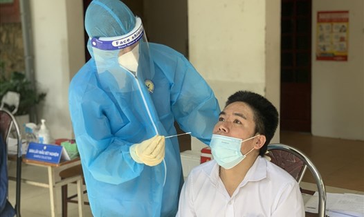 Cán bộ y tế lấy mẫu xét nghiệm COVID-19 cho người dân ở Hà Nội. Ảnh: Hương Giang