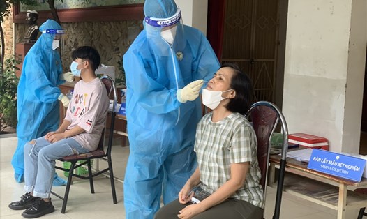 Cán bộ y tế lấy mẫu xét nghiệm COVID-19 cho người dân ở Hà Nội. Ảnh: Hương Giang