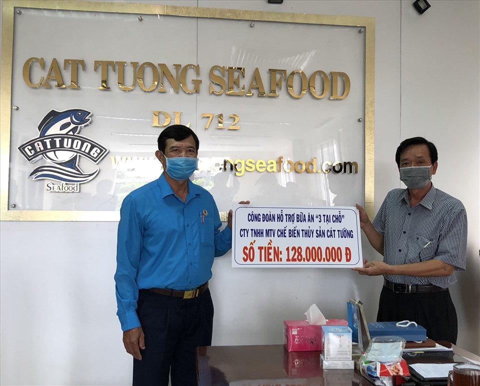 Chủ tịch LĐLĐ tỉnh Vĩnh Long Huỳnh Bá Long trao biển tượng trưng hỗ trợ bữa ăn cho công nhân lao động sản xuất “3 tại chỗ” Công ty chế biến thủy sản Cát Tường. Ảnh: Ngọc Long