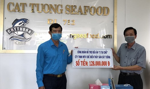Chủ tịch LĐLĐ tỉnh Vĩnh Long Huỳnh Bá Long trao biển tượng trưng hỗ trợ bữa ăn cho công nhân lao động sản xuất “3 tại chỗ” Công ty chế biến thủy sản Cát Tường. Ảnh: Ngọc Long