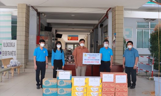 Ông Trần Lê Duy - Tỉnh ủy viên, Chủ tịch Liên đoàn Lao động tỉnh Tây Ninh (người thứ 2 từ phải qua) trao quà hỗ trợ cho Trung tâm Y tế thị xã Trảng Bàng.