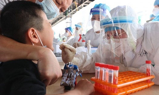 Một em nhỏ lấy mẫu xét nghiệm COVID-19 ở thành phố Hạ Môn, tỉnh Phúc Kiến, Trung Quốc. Ảnh: AFP