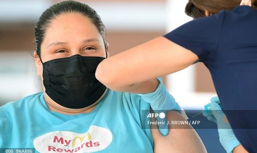 Một người phụ nữ được tiêm liều vaccine Pfizer đầu tiên ở California, Mỹ, ngày 21.9.2021. Ảnh: AFP