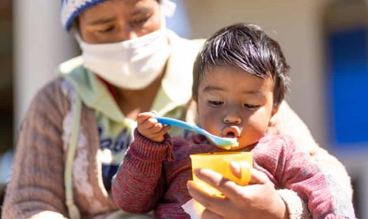 Một trẻ nhỏ ăn trái cây do UNICEF trao tại một ngôi làng ở Guatemala. Ảnh: UNICEF