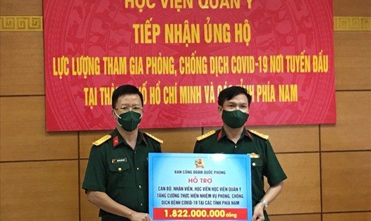 Đại tá Nguyễn Đình Đức (bên trái) trao hỗ trợ 1.822.000 đồng cho lực lượng Học viện Quân y tăng cường các tỉnh phía Nam chống dịch. Ảnh: Kiều Vũ