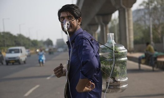 Một thanh niên tên là Pankaj Kumar đeo mặt nạ dưỡng khí nối với một bình nhựa kỳ lạ. Anh chàng được trông thấy ở Noida, ngoại ô Delhi, Ấn Độ, vào ngày 1.12.2019. Ảnh: AFP