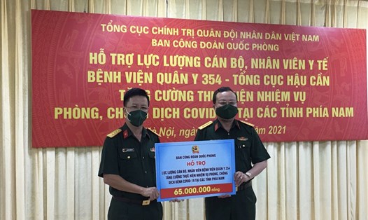 Đại tá Nguyễn Đình Đức (bên trái) trao hỗ trợ cho cán bộ, nhân viên y tế Bệnh viện Quân y 354 tăng cường thực hiện nhiệm vụ chống dịch tại các tỉnh phía Nam. Ảnh: Kiều Vũ