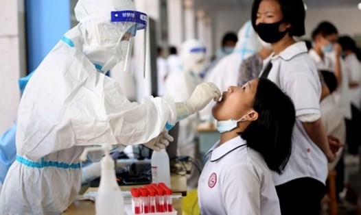 Nhân viên y tế lấy mẫu xét nghiệm COVID-19 cho một nữ sinh ở Trung Quốc, ngày 15.9.2021. Ảnh: Tân Hoa Xã