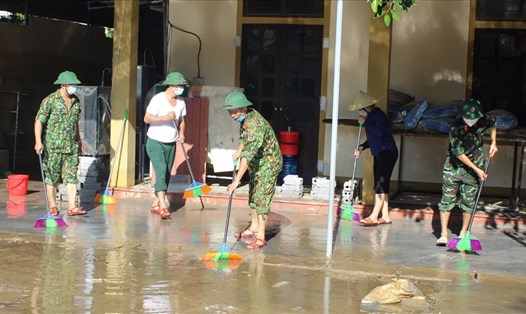 Bộ đội giúp người dân vùng lũ Quỳnh Lưu lau dọn nhà cửa khi nước vừa rút. Ảnh: Quang Đại