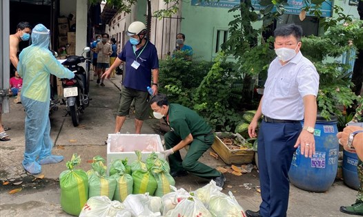 Ông Nguyễn Thanh Tâm - Chủ tịch UBND thành phố Thuận An (bìa phải) xuống địa bàn chỉ đạo công tác hỗ trợ lương thực, thực phẩm cho người dân. Ảnh: T.Liêm