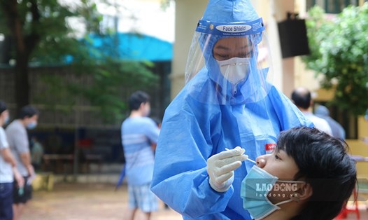 Nhân viên y tế lấy mẫu xét nghiệm cho người dân tại phường Láng Thượng (quận Đống Đa, Hà Nội). Ảnh T.Vương