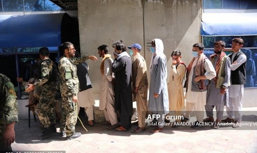 Người Afghanistan xếp hàng bên ngoài ngân hàng để rút tiền mặt sau khi Taliban tiếp quản thủ đô Kabul. Ảnh: AFP