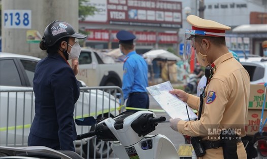 Cảnh sát giao thông kiểm tra giấy đi đường tại Hà Nội. Ảnh Tô Thế.
