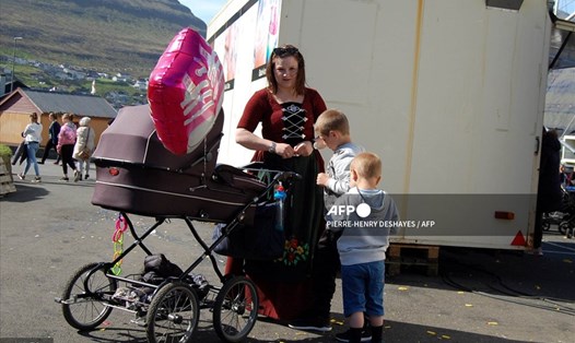 Một phụ nữ Đan Mạch trong trang phục truyền thống cùng các con tham dự một lễ hội ở Klaksvík. Ảnh minh họa. Ảnh: AFP