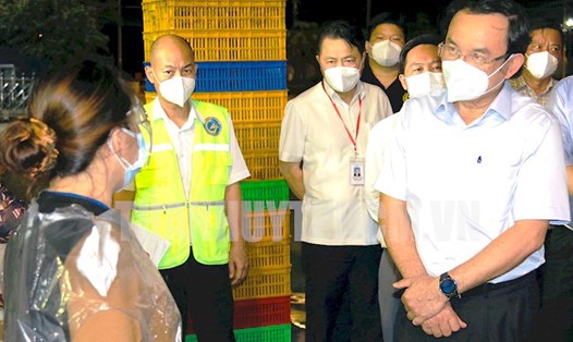 Bí thư Thành ủy TPHCM Nguyễn Văn Nên trao đổi với các tiểu thương tại chợ Bình Điền.  Ảnh: Long Hồ