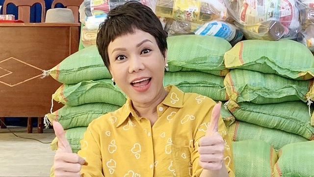 Việt Hương tiếp tục trao gạo cho người dân. Ảnh: NSCC.