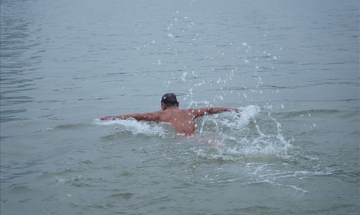 Dù trời lạnh, nhiều người vẫn giữ thói quen bơi trên sông Hồng mỗi ngày. Ảnh: PV.