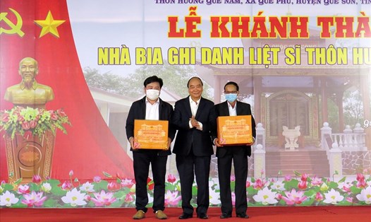 Chủ tịch nước Nguyễn Xuân Phúc tặng quà cho các gia đình liệt sĩ ở thôn Hương Quế Nam. Ảnh: Thanh Chung