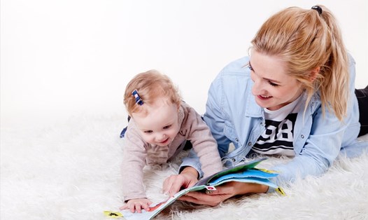 Đọc truyện cho trẻ là một trong những cách giúp các bé nâng cao khả năng ghi nhớ. Ảnh: Xinhua