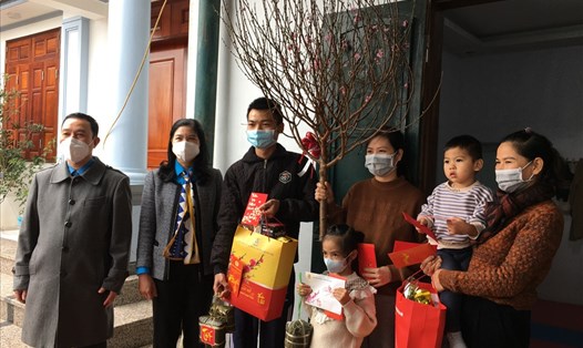 Bà Đặng Thị Phương Hoa (thứ hai từ trái sang) và ông Đinh Quốc Toản (thứ nhất từ trái sang) trao quà Tết cho gia đình công nhân ở lại nhà trọ, không về quê ăn Tết Nguyên đán Nhâm Dần 2022. Ảnh: Kiều Vũ
