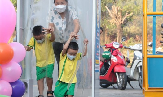 Trẻ mầm non ở thị xã Bến Cát khử khuẩn trước khi vào trường. Ảnh: Đình Trọng
