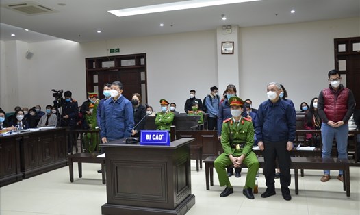 Cựu Giám đốc Bệnh viện Bạch Mai Nguyễn Quốc Anh (đứng, trái) cùng các bị cáo tại phiên toà sơ thẩm. Ảnh: V.D