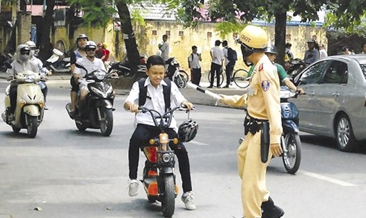 Đi xe đạp điện không đội mũ bảo hiểm sẽ bị xử phạt vi phạm hành chính. Ảnh: LDO