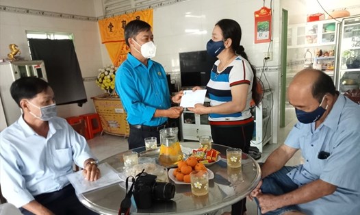 Phó Chủ tịch LĐLĐ tỉnh An Giang Nguyễn Hữu Giang trao suất hỗ trợ 05 triệu đồng đến gia đình em Lê Hoàng Minh.