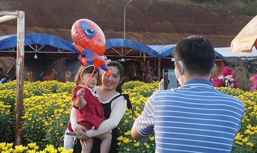 Người dân đi thăm quan chợ hoa Tết ở thành phố Gia Nghĩa. Ảnh: Phan Tuấn