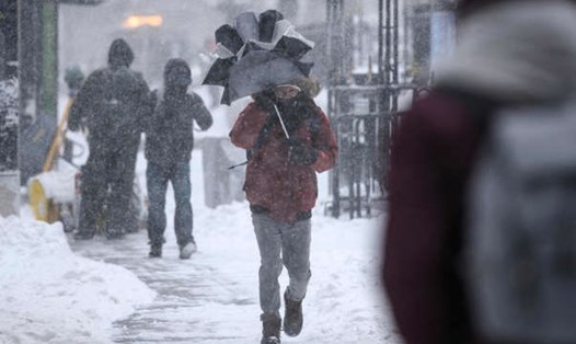 Người dân đi trên đường phố New York, Mỹ giữa trận bão tuyết mạnh đổ bộ hôm 29.1. Ảnh: AFP