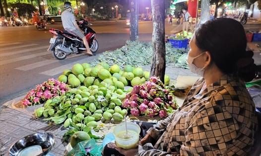 Bà Đoàn (61 tuổi, ngụ TP.Thủ Đức) cố gắng bán hàng trong đêm Giao thừa. Ảnh: Huyên Nguyễn