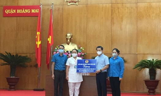 Chủ tịch Công đoàn ngành Y tế Hà Nội Trịnh Tố Tâm (ngoài cùng bên trái) trao hỗ trợ cho nhân viên y tế quận Hoàng Mai trong đợt dịch thứ 4. Ảnh: Kiều Vũ