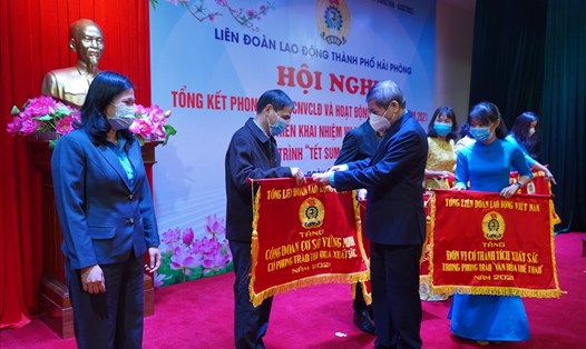 Đồng chí Trần Thanh Hải - Phó Chủ tịch Thường trực Tổng LĐLĐ VN trao cờ thi đua của Tổng LĐLĐ tặng các tập thể có thành tích xuất sắc năm 2021. Ảnh: Mai Dung