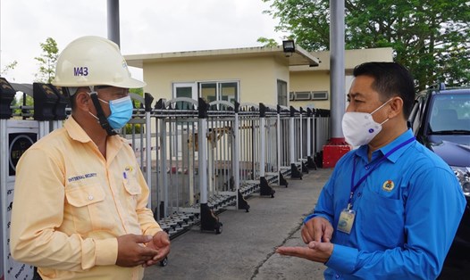 Ông Huỳnh Sơn Tuấn (áo xanh) đang trao đổi cùng một đơn vị trong Khu Công nghiệp về công tác phòng chống dịch và chăm lo cho người lao động. Ảnh: T.A