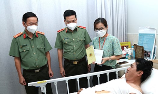 Thiếu tướng Nguyễn Sỹ Quang (thứ 2 từ trái qua) cùng đoàn công tác hỏi thăm tình hình sức khỏe của thiếu tá Lâm. Ảnh: CA ĐN