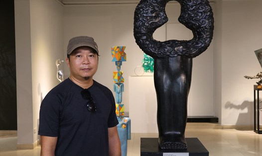 Nhà điêu khắc Lương Định và tác phẩm “mây trôi”. Ảnh: Việt Phong