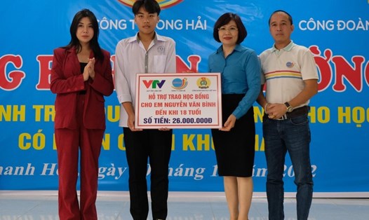 Bà Đặng Hoàng Anh (thứ 2 bên phải) cùng đại diện Quỹ Tấm lòng Việt, nhà tài trợ trao học bổng tới em Nguyễn Văn Bình. Ảnh CĐ