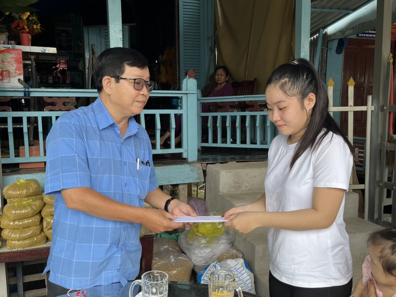 Đại diện gia đình nạn nhân Lê Gia Qui nhận tiền hỗ trợ từ đoàn công tác. Ảnh: Thành Luân