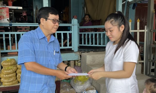 Đại diện gia đình nạn nhân Lê Gia Qui nhận tiền hỗ trợ từ đoàn công tác. Ảnh: Thành Luân