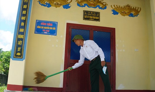 Doanh nhân già Nguyễn Văn Sửu bên ngôi nhà thờ liệt sĩ mà ông bỏ tiền tài trợ xây dựng. Ảnh: Trần Tuấn.