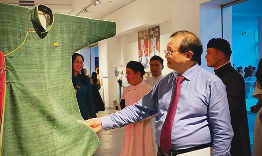 Thứ trưởng Bộ VHTTDL Tạ Quang Đông chiêm ngưỡng sản phẩm áo ngũ thân của Nguyễn Minh Đời. Ảnh: TL