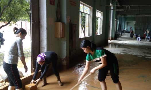 Công nhân dọn bùn nhà máy sau mưa lũ. Ảnh: Thành Trung