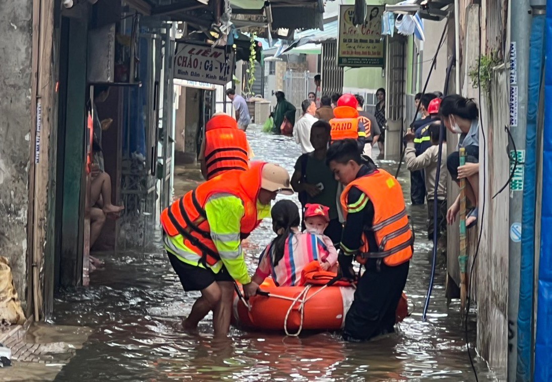 Lực lượng Thủy đoàn I cùng cán bộ địa phương giúp dân rời khỏi nơi nước lũ. Ảnh: Thủy đoàn I