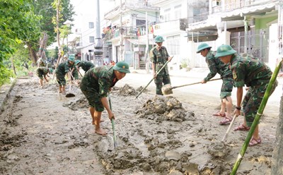Lực lượng vũ trang giúp dân dọn dẹp bùn đất sót lại sau mưa lũ.