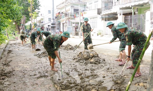 Lực lượng vũ trang giúp dân dọn dẹp bùn đất sót lại sau mưa lũ.