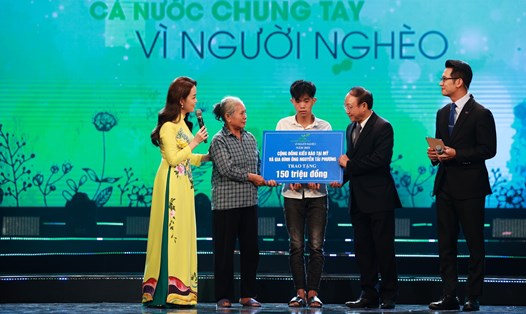 Em Nguyễn Văn Tuấn nhận số tiền hỗ trợ 150 triệu đồng tại chương trình. Ảnh: Hải Nguyễn