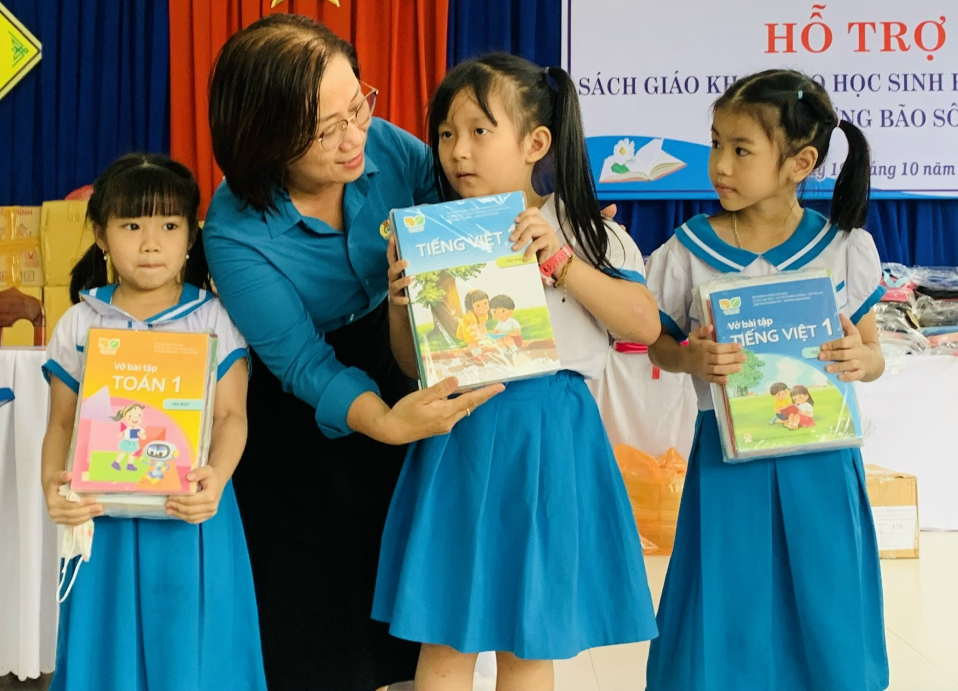 Bà Đinh Thị Thanh Hà, Phó Chủ tịch Liên đoàn Lao động thành phố Đà Nẵng trao tặng sách giáo khoa cho học sinh Trường Tiểu học Nguyễn Văn Trỗi. Ảnh: H.V.M