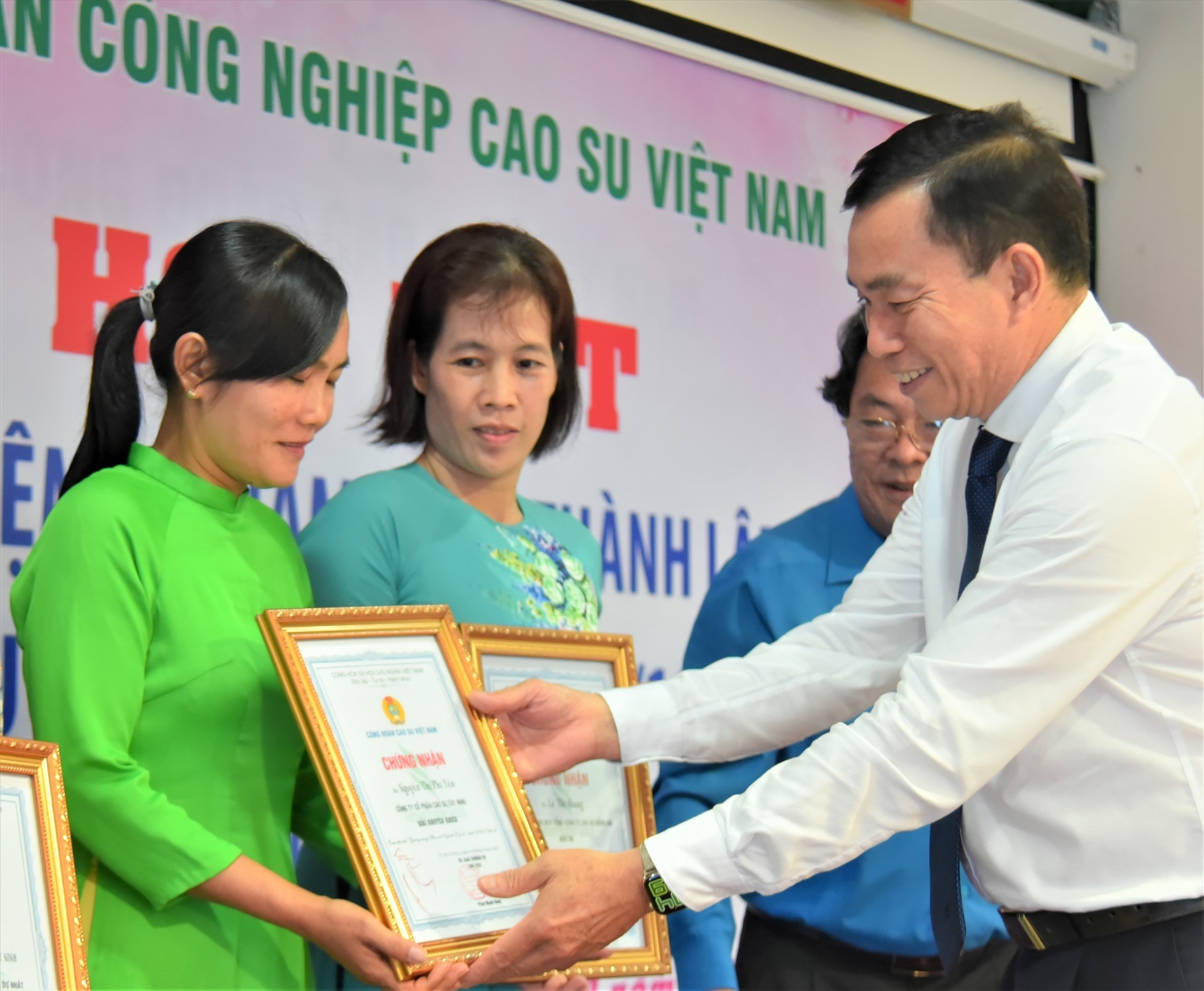 Ông Lê Thanh Tú - Phó Tổng Giám đốc Tập đoàn Công nghiệp Caosu Việt Nam - trao Giấy chứng nhận cho tác giả đoạt giải cuộc thi viết về "Gương sáng phụ nữ ngành Caosu Việt Nam". Ảnh: Nam Dương