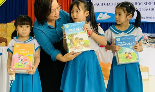 Bà Đinh Thị Thanh Hà, Phó Chủ tịch LĐLĐ thành phố Đà Nẵng trao tặng sách giáo khoa cho học sinh Trường Tiểu học Nguyễn Văn Trỗi. Ảnh: HVM