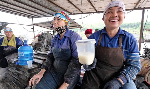 Chị Nguyễn Thị Nhàn - phụ trách công đoàn tổ vừa vui đùa, vừa “khoe” bình cháo trắng mang từ nhà ra dùng trong giờ nghỉ giải lao.